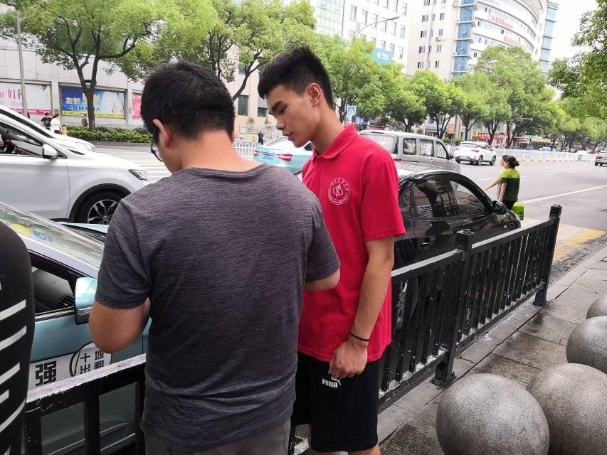 图为实践队员杨亮在湖北医药学院街进行问卷调查。