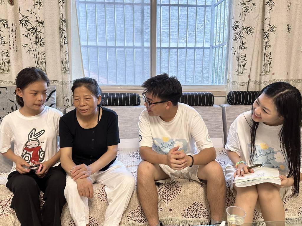 图为放学后志愿者在与家长取得联系后对本班学生进行家访过程中志愿者与家长对话。中国青年网通讯员 何敏 摄