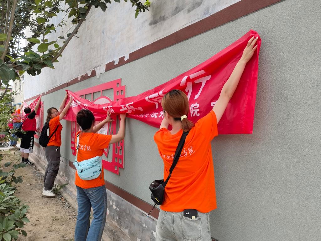 图为实践团成员在张贴用电安全宣传横幅。 中国青年网通讯员 李静怡 摄