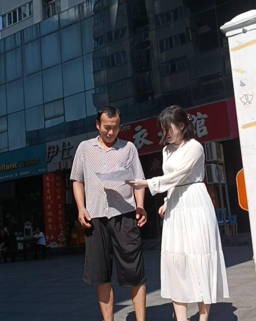 图为实践队员向市民进行普法宣讲。中国青年网通讯员张颖供图