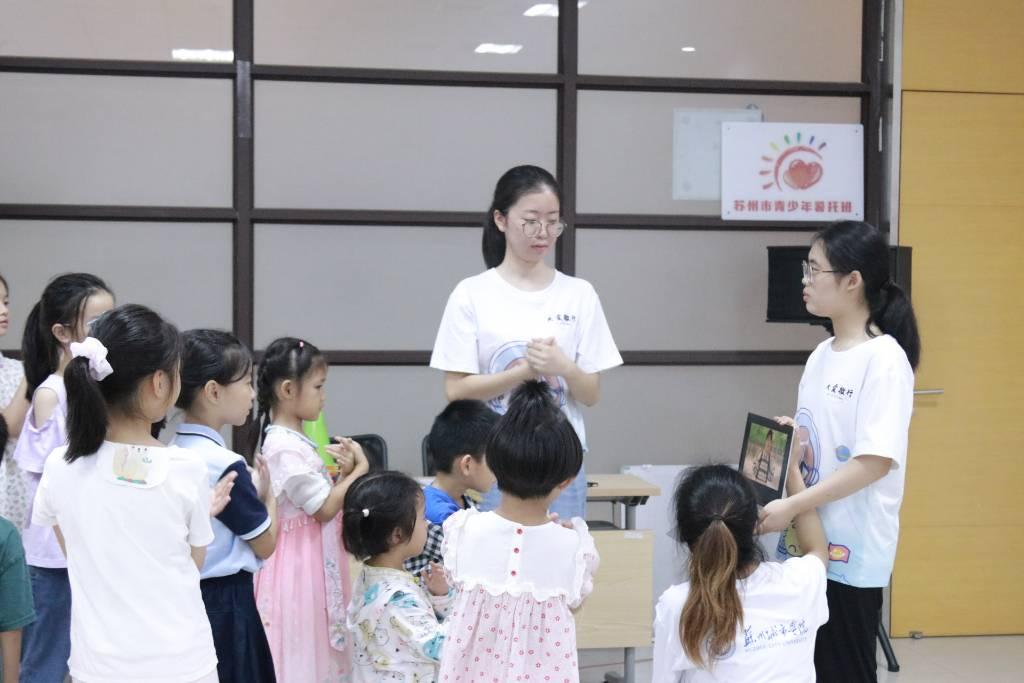 图为苏州城市学院志愿者带领小朋友学习手势舞。