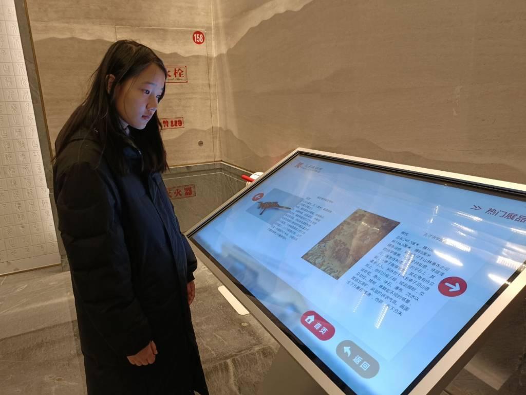 图为绘梦筑基实践队队员用数字媒体参观孔子博物馆展品介绍。