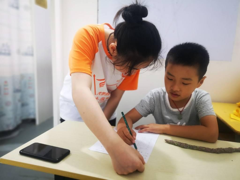志愿者指导孩子走出自我，集中注意，画出未来。中国青年网通讯员 徐心怡 摄
