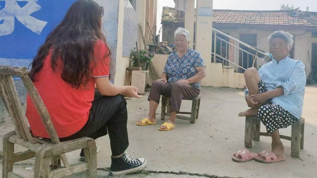 实践团成员拜访社区老人，与她们谈心。